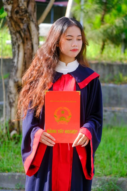 Graduate holding diploma in graduation gown